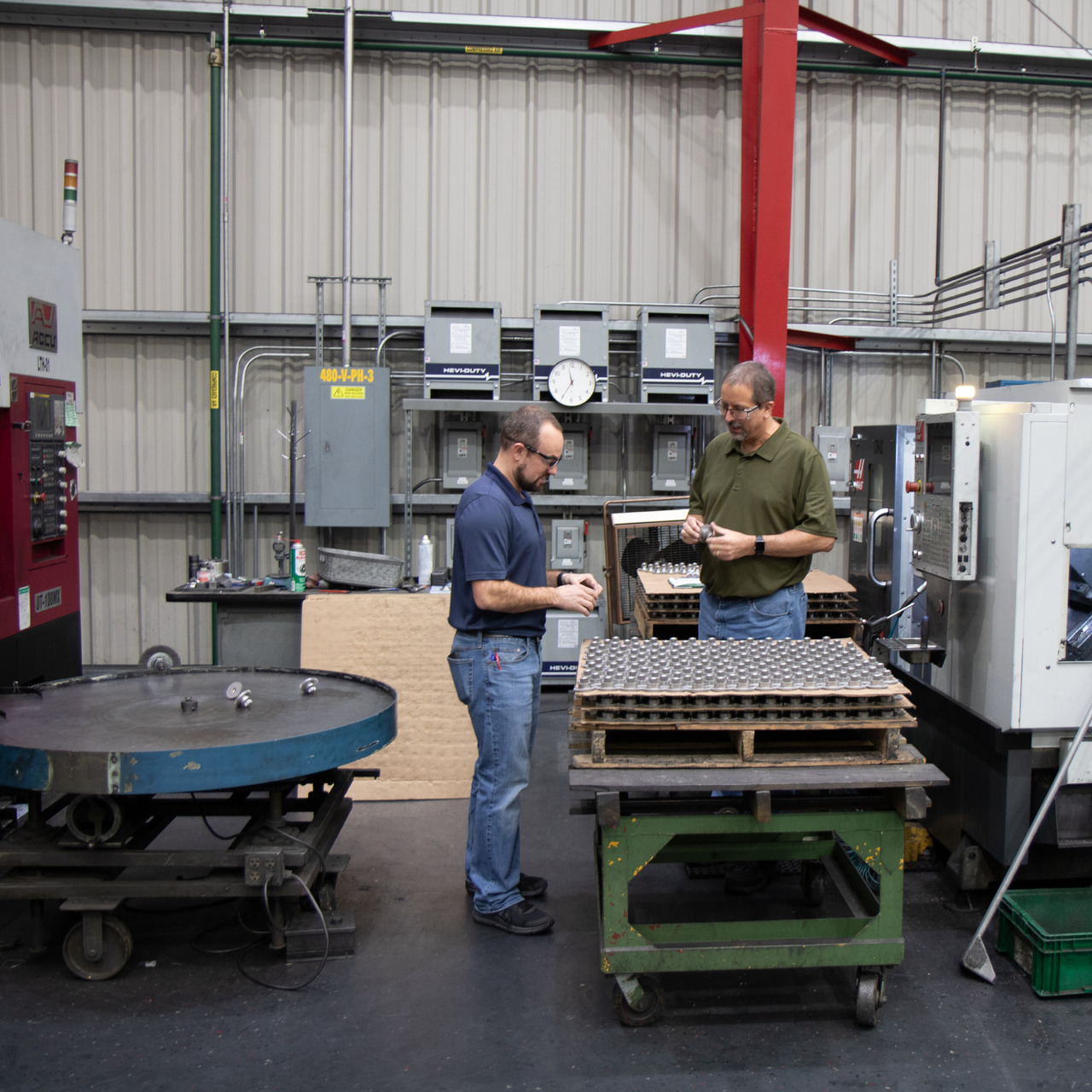 Two men inspecting part in warehouse
